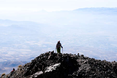 Hiker ascending top of volcanic mountain