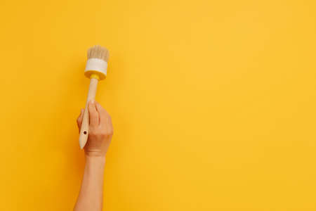 Hand holding paint brush