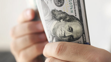 Man counting american dollars banknotes