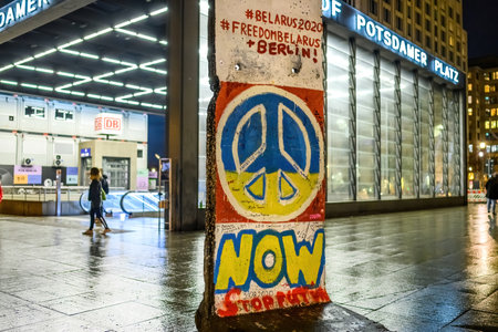 Peaceful sign in ukrainian flag colors on a broken Berlin wallのeditorial素材