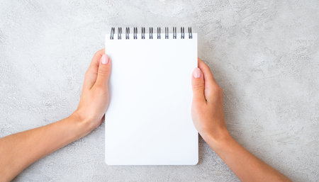 Girl holding white notebook view from above