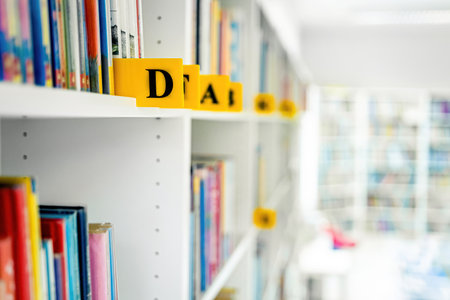 Books on shelves in the light library for kids. Authors of books placed by alphabet.