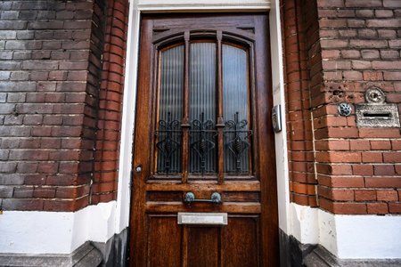 Wooden door with glass in european residential brick building. House entrance and stone traditional facadeの写真素材