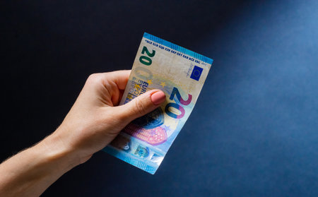 Hand holding twenty euro banknote after money exchange. European currency in cash as symbol of successの写真素材