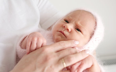 Caring Mom Soothing Her Cute Newborn Baby Girl To Sleep In Her Armsの写真素材