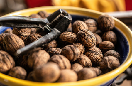 Walnuts and nutcracker in bowl closeup. Delicious nuts for vegetarian heathy diet