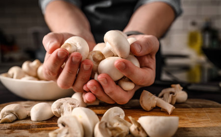 Chief man hands holding shampignons at kitchen. Restaurant professional with edible mushrooms from woodの写真素材
