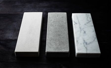 Three Sharpening Stones For Kitchen Knives On A Wooden Tableの写真素材