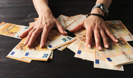 Girl Struggling To Keep Her Euro Banknotesの写真素材