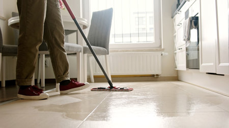 Lady Cleaning Kitchen Tile Floor With Mop