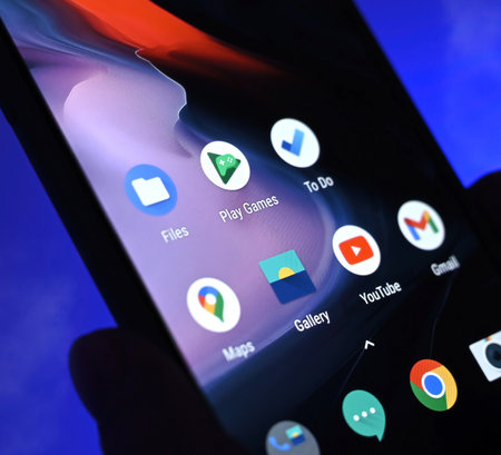 Poznan, Poland - 13 January: Smartphone with apps icons against blue background. Choosing social media application.のeditorial素材