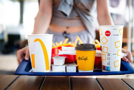 Poznan, Poland - 28 August 2024: Young Girl Serving Fast Food On Tray At Mcdonaldsのeditorial素材