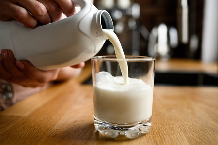 Pouring milk in glass from a white bottle