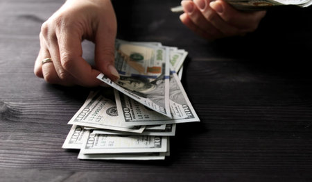 Lady Calculating Her Money Savings In Us Dollar Bills