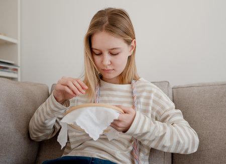 Sweet Little Girl Learns To Embroider On A Hoop At Homeの写真素材
