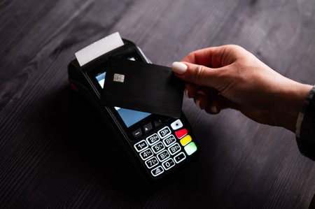 Girl Holding Card In Hand Paying By Credit Card With Wireless Pos Terminalの写真素材