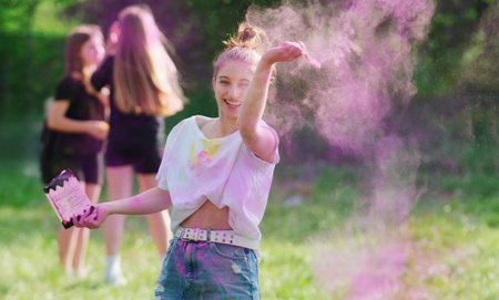 Girl Tossing Vibrant Holi Powder Paint During Holi Festivalの写真素材