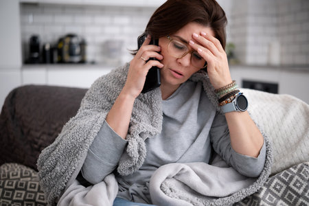 Young Woman Sick At Home And Calls The Doctor For High Fever And Headacheの写真素材