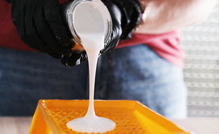 Repairman Pours White Paint Into A Tray, Preparing For Home Renovationの写真素材