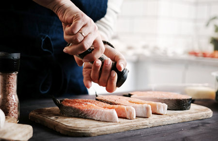 Woman Salting Raw Red Salmon For Cooking Close Upの写真素材