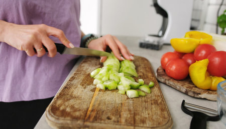 Girl Close Up Cutting A Cucumber On A Cutting Board For A Vegetable Salad