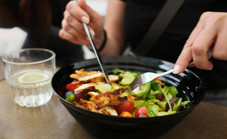 Girl Enjoying Delicious Chicken Salad With Fruits And Veggies In A Cafeの写真素材