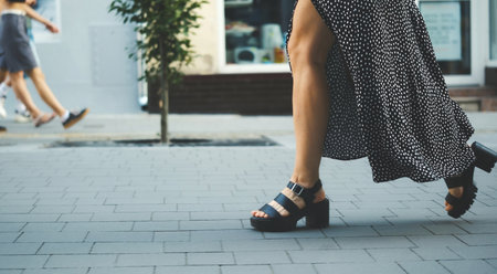 Stylish Young Woman In A Dress Walking The Street In High-Heeled Shoesの写真素材