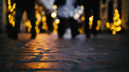 People's Feet Walking On The Cobblestone Pavement In The Glowing, Decorated Christmas Street In The City Centerの写真素材