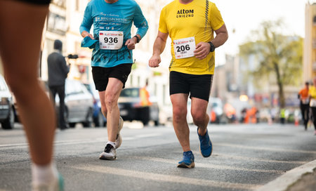 Gniezno, Poland - 11 April 2026: European 10 kilometer city run through historic streets of Gniezno Poland. Group of athletes sprinting toward finish line.