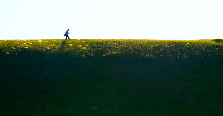 About the photographer.The way of the photographer under weight of equipment and knowledge passes over break and under sunshine of good luck and glory.の写真素材