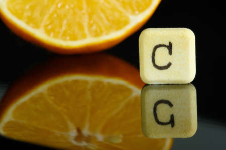 Vitamin C and lemon with reflection in blackの写真素材