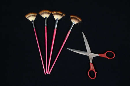 Set of round art paintbrushes and  scissors on black