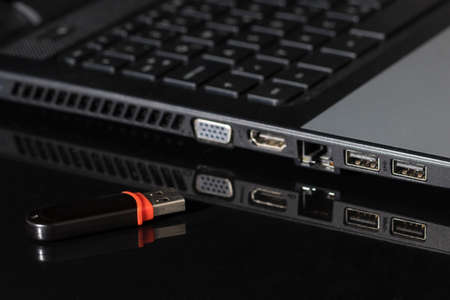 USB Flash drive on computer laptop on blackの写真素材