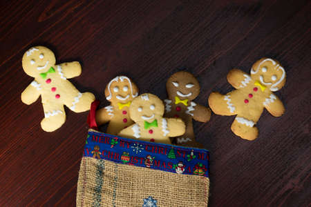 Group of funny gingerbread cakes in Christmas sock on wooden table