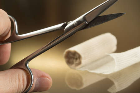 Man man holding Scissors and bandage, First aidの写真素材