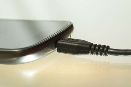 Charging battery of black smart phone, with USB cable