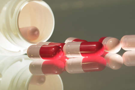Closeup of Red and pink antibiotics capsule and bottle