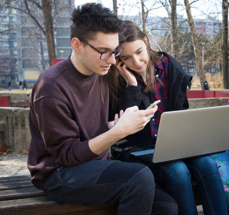 Portrait of boy and girl high school teenager students with laptop in the playgroundの写真素材