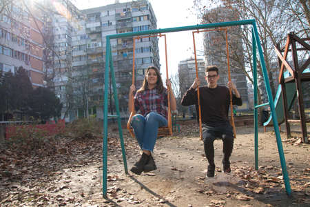 Two happy smiling teenager  on the swingの写真素材