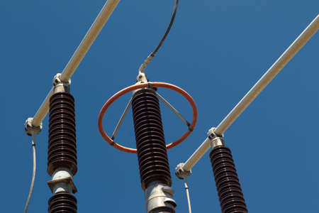 Red and brown high voltage isolation with ceramic body on blue skyの写真素材