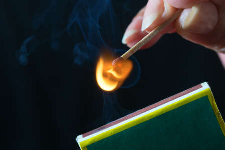 Woman striking a match and make a fireの写真素材