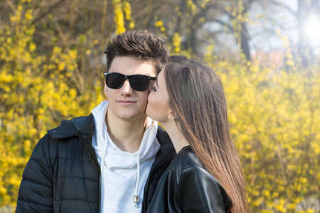 A giril and boy is kissing in the floral park on Valentines dayの写真素材