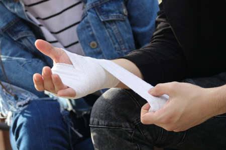 Close up of bandaging injured hand after an accidentの写真素材