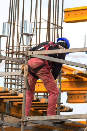 Worker is build metal scaffolding on construction site