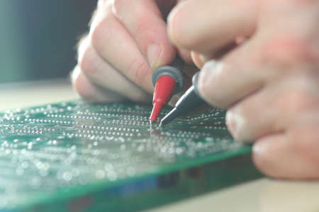 Technician test electronic component on the circuit board