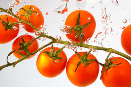 Closeup of red ripe cherry tomatoes under waterの写真素材