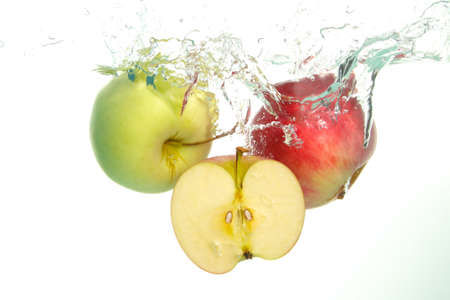 Apples and aple slice splash in water on white bckgroundの写真素材