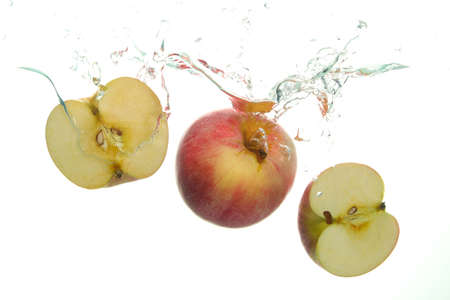 Red Apple and and two aple slices splash in water on white backgroundの写真素材