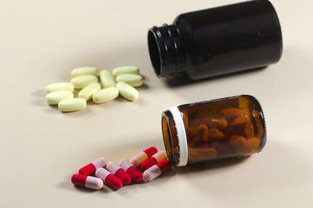 Two bottles of colorful antibiotic pills and tabletsの写真素材