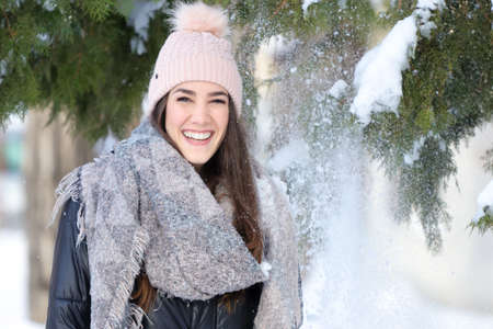 Portrait of  Smiling girl in winter with snow and christmas treeの写真素材